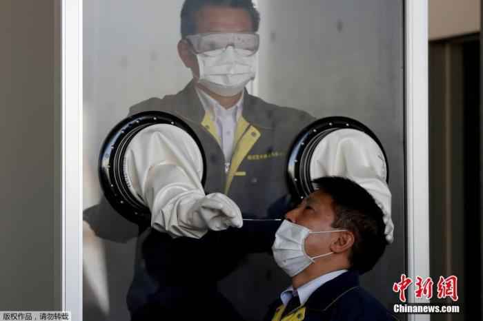 日本横须贺市,医务人员在一个箱状的临时检疫设施中模拟对人们进行核酸检测。 调查显示新冠患者嗅觉和味觉大幅减弱